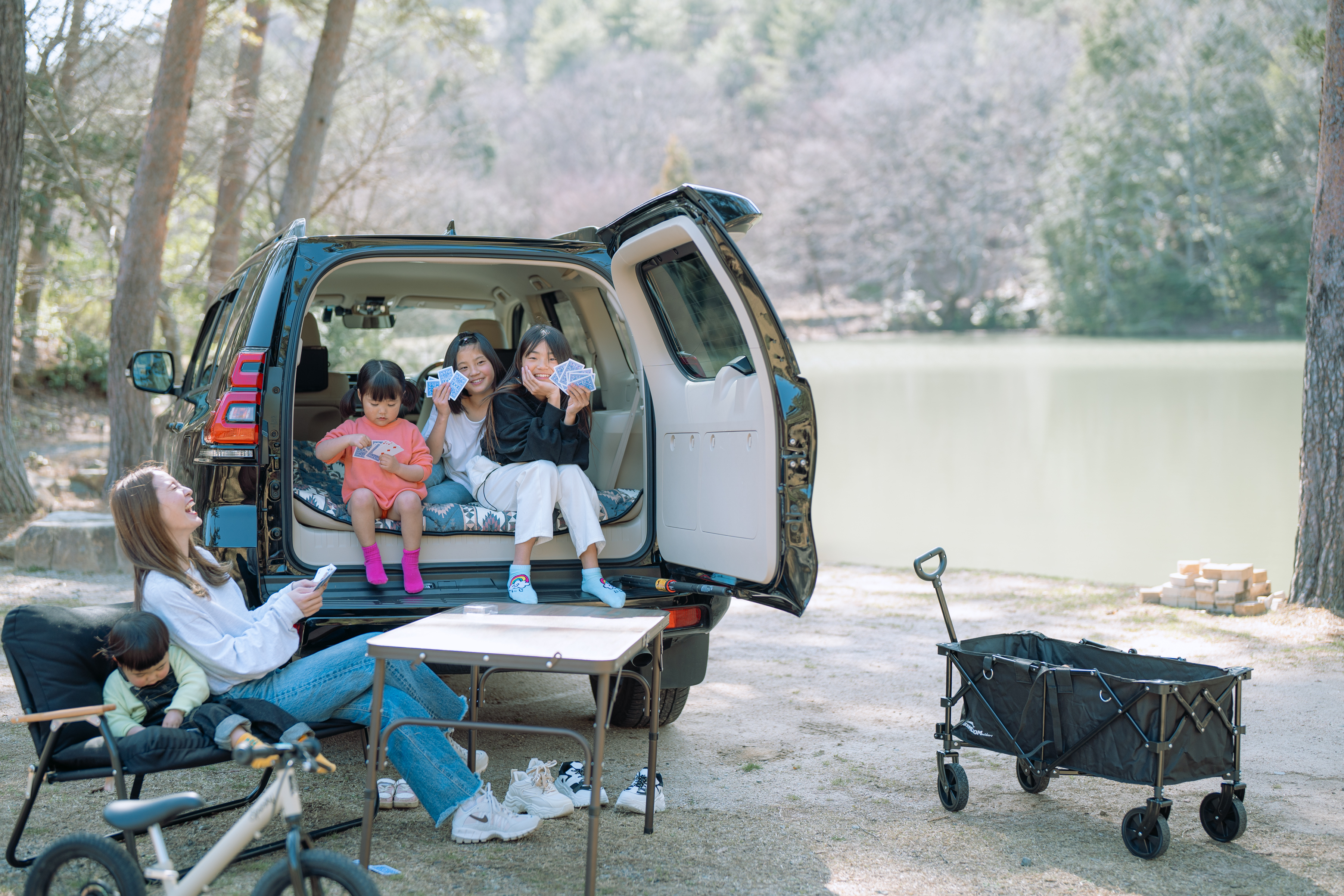 自然の中で車のそばに集まり、くつろぎの時間を過ごす様子